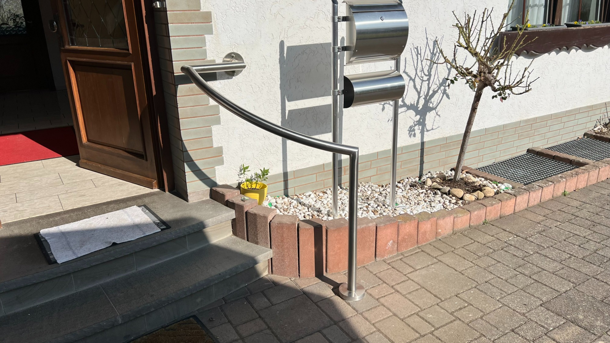 Gebogener Edelstahlhandlauf an Eingangstür